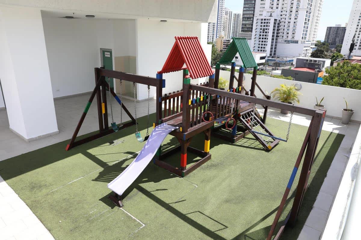 Kids play area with slide and swings at PH Quartz Tower with high-rise view San Francisco Panama