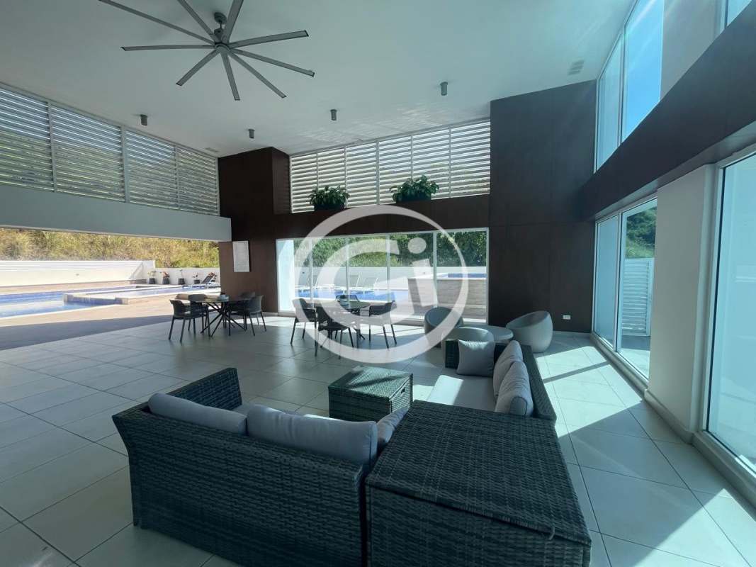 Common lounge area with wicker furniture and pool view at PH Country Heights Condado del Rey