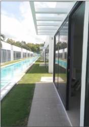 Large outdoor pool with walkways and poolside view in PH Ibiza Beach Residences Santa Clara