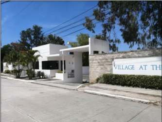 Modern gated entrance with signage and security booth at PH Ibiza Residences Panama