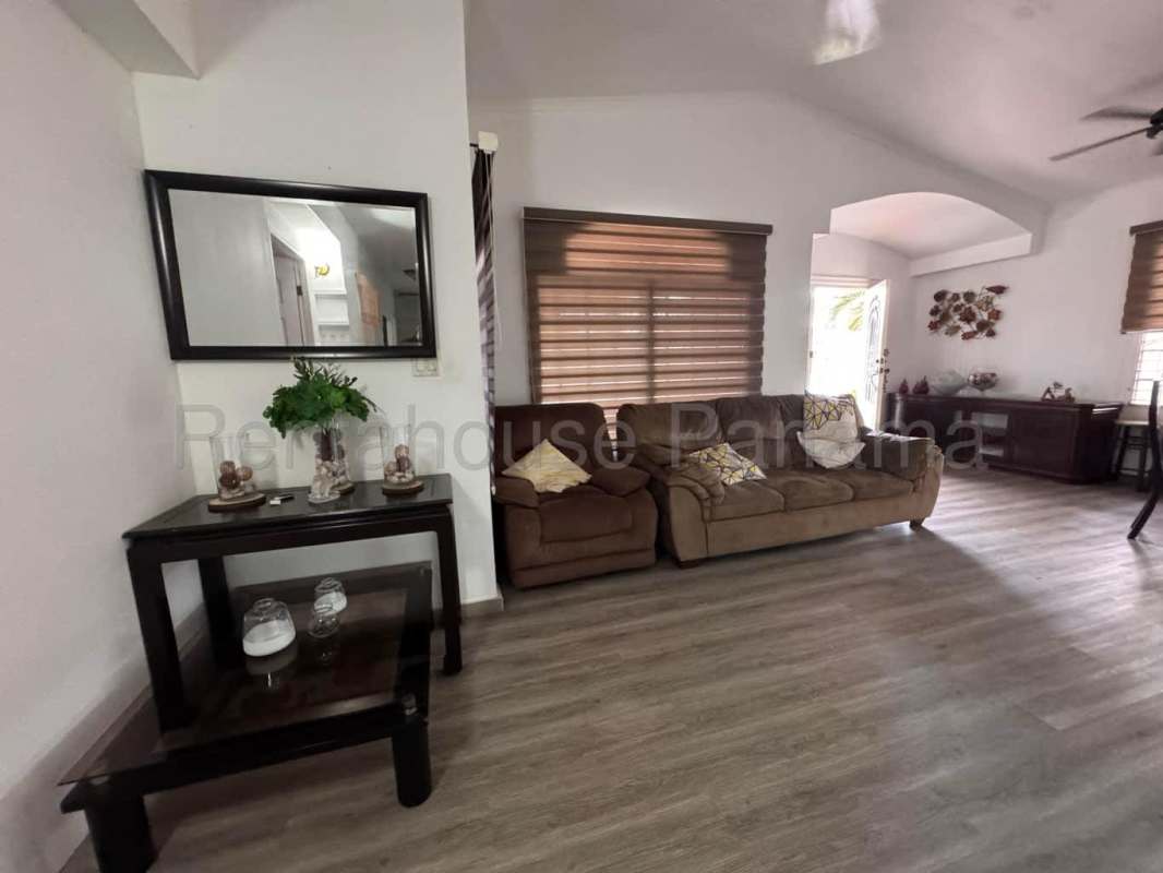 Living room with decorative entertainment wall, ceiling fan and wood-look floor Villa Lucre Panama
