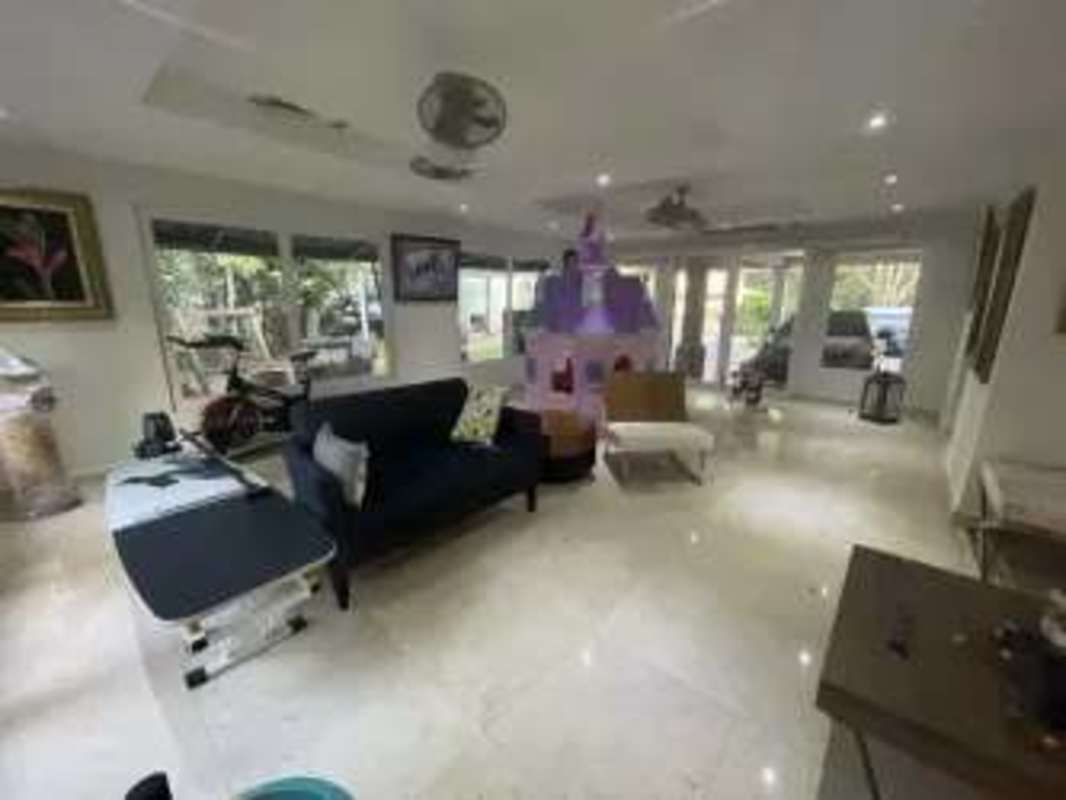 Contemporary living room with garden views, black sofa, play area in Clayton luxury house