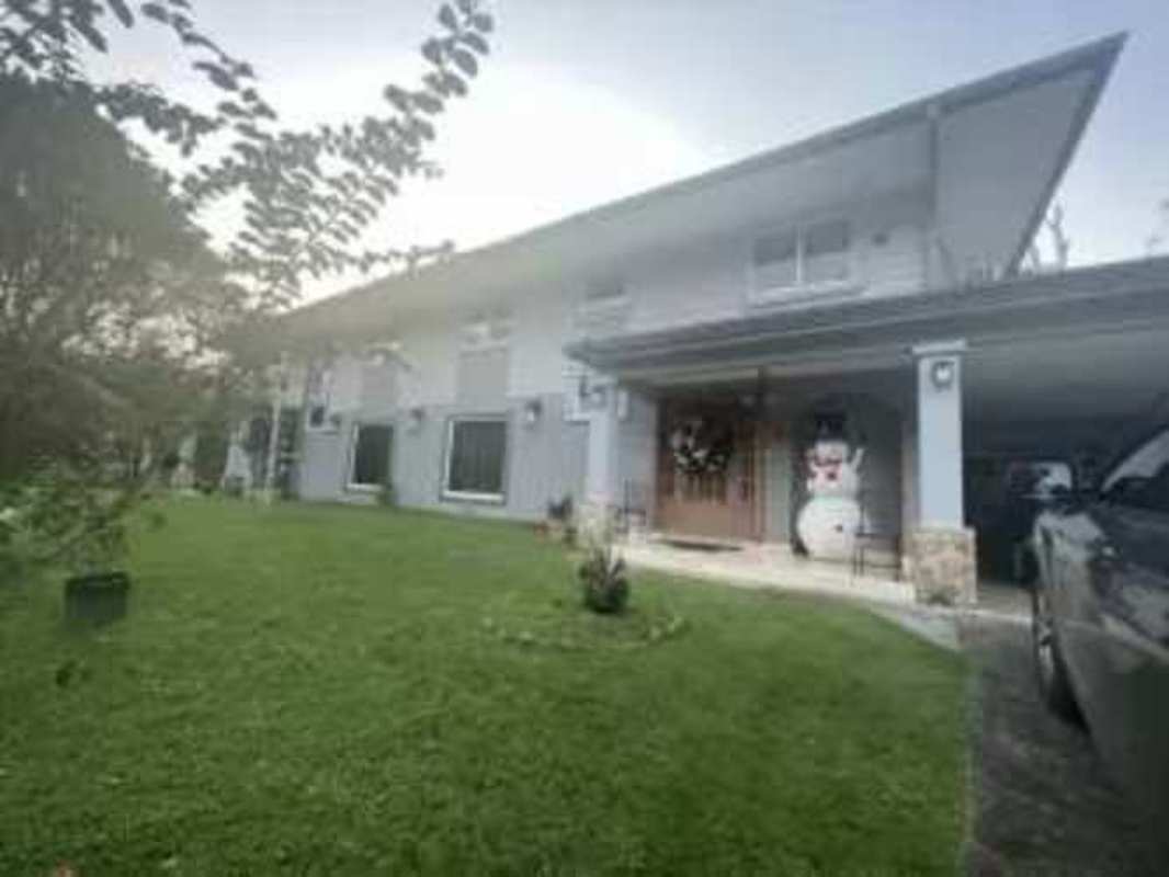 Two-story modern suburban house with carport, holiday decor and lush front yard Clayton Panama