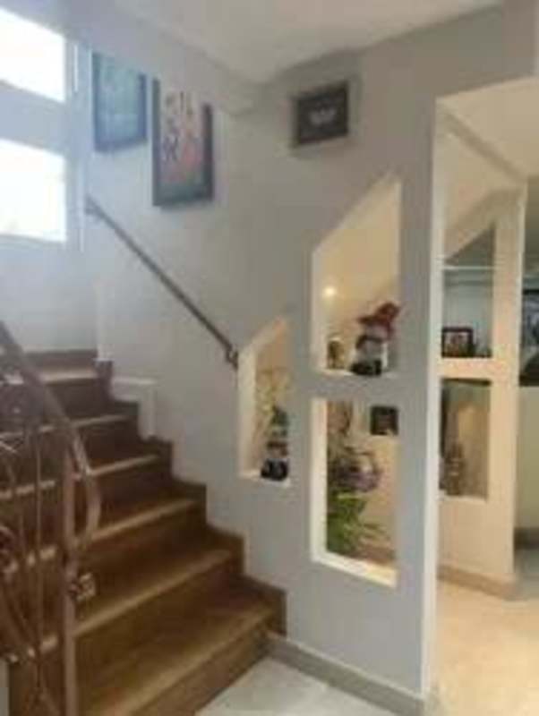 Interior staircase with wooden steps, decorative niches, and natural lighting in Clayton house