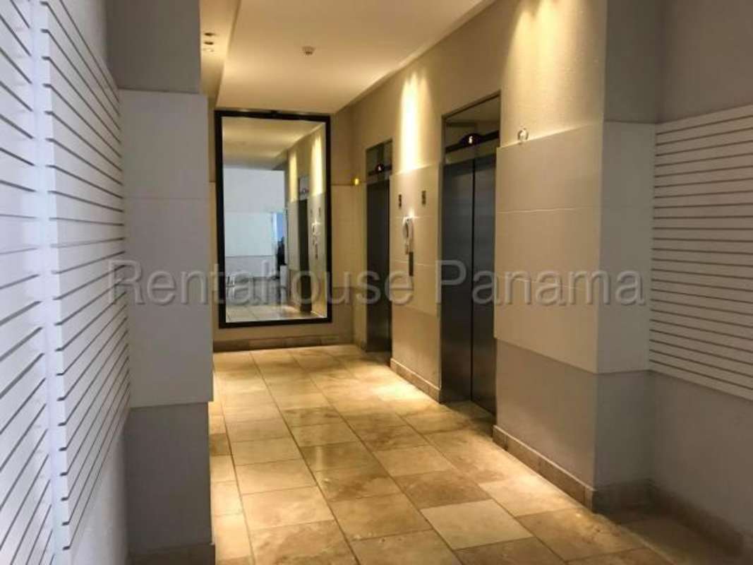 Double height living area with panoramic windows and urban views in PH Vitro Loft Panama City