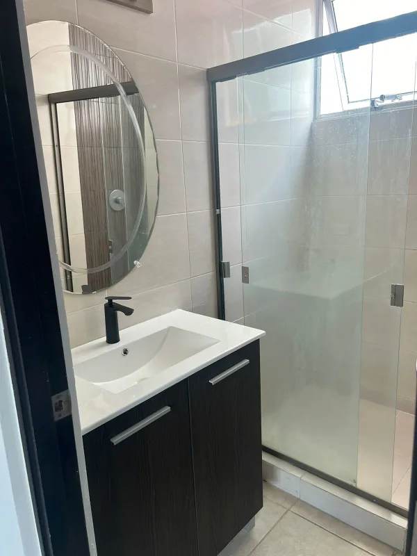 Modern bathroom with glass shower enclosure, vanity sink at PH Clayton Park Clayton Panama