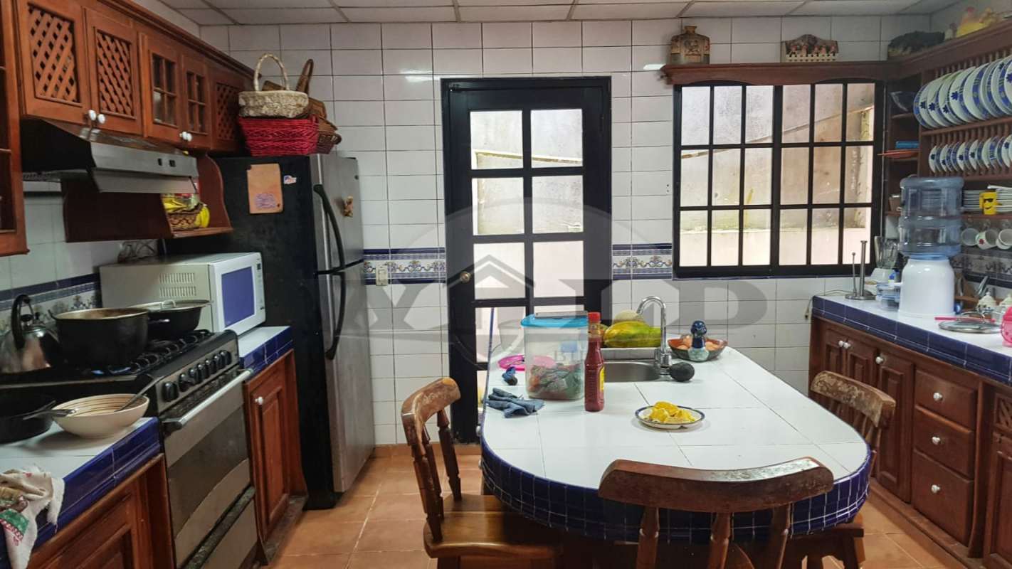 Traditional dining room with rustic staircase and natural light in mountain villa Cerro Azul Panama
