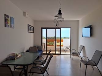Open plan living dining with tile floors leading to ocean balcony in Playa del Sol