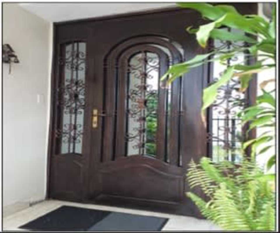 Traditional ornate wooden entrance door with iron grille Pueblo Nuevo Panama