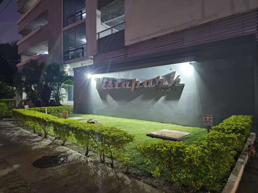 Night view of Vista Park Towers facade with signage and landscaping in Carrasquilla Panama