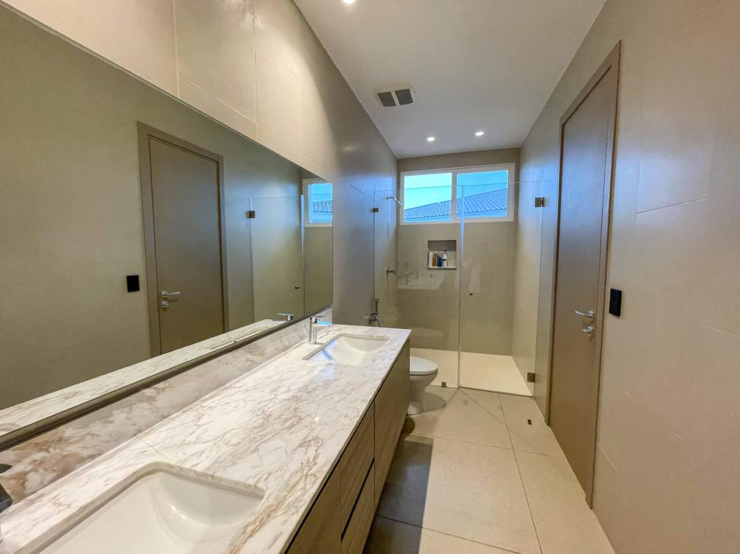 Elegant master bedroom with large windows, lake view, and walk-in closet at Santa María The Grove house