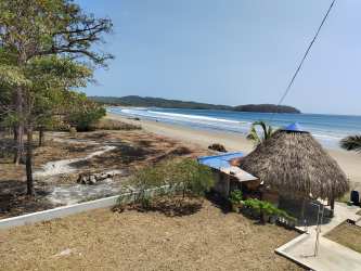 Beachfront property with palapa hut overlooking sandy shoreline and ocean at Playa Venao Panama