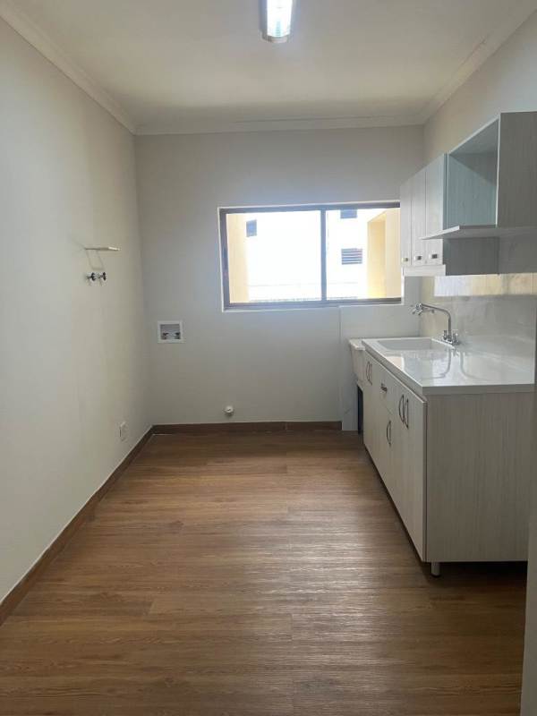 Laundry room with wood-style flooring, cabinetry, utility sink, and large window in PH El Cangrejo El Cangrejo Panama City