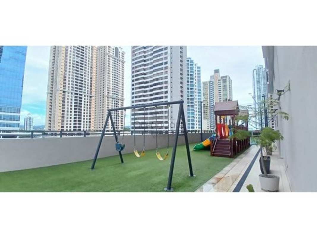 Rooftop playground with swings, slides, artificial turf with city backdrop at PH Matisse Costa del Este