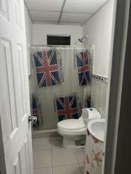 Spacious living room with stone accent wall and mounted TV Quintas de Pilón Colón Panama