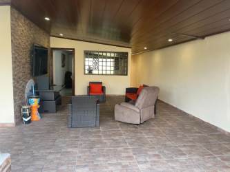 Covered terrace with tiled flooring stone wall accents fenced backyard Quintas de Pilón Colón Panama