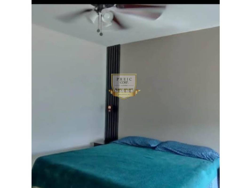 Minimalist bedroom with accent wall, teal bedding, ceiling fan Costa Sur Panama