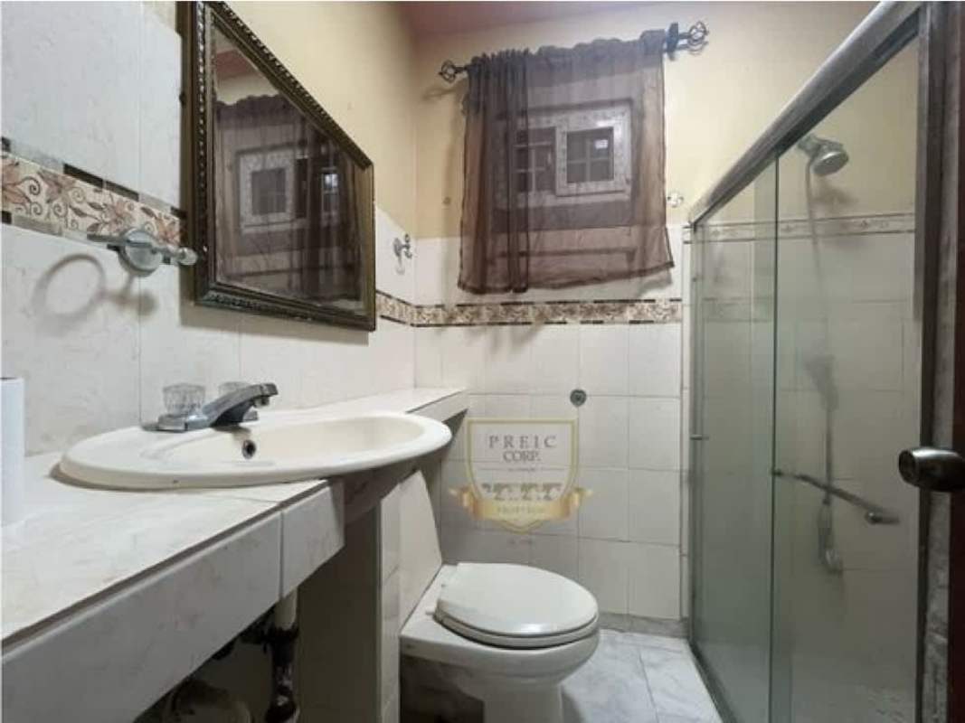 Bathroom with glass-enclosed shower, beige tile, single vanity in Panama affordable house