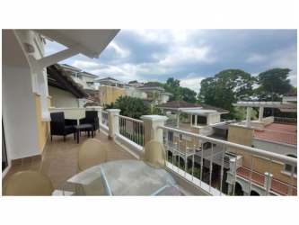 Elegant Mediterranean facade of townhouses with balconies and lush landscaping at Tucan Country Club Panama