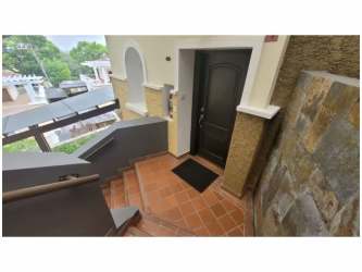 Living and dining area in townhouse rental at Tucan Country Club Panama with large windows and terrace access