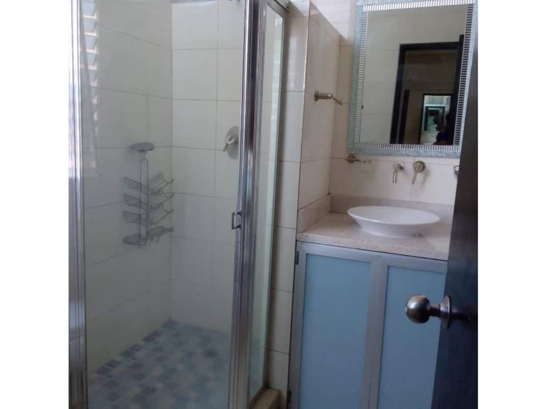 Dining table and open kitchen with modern finishes in PH Calle 77 Panama City