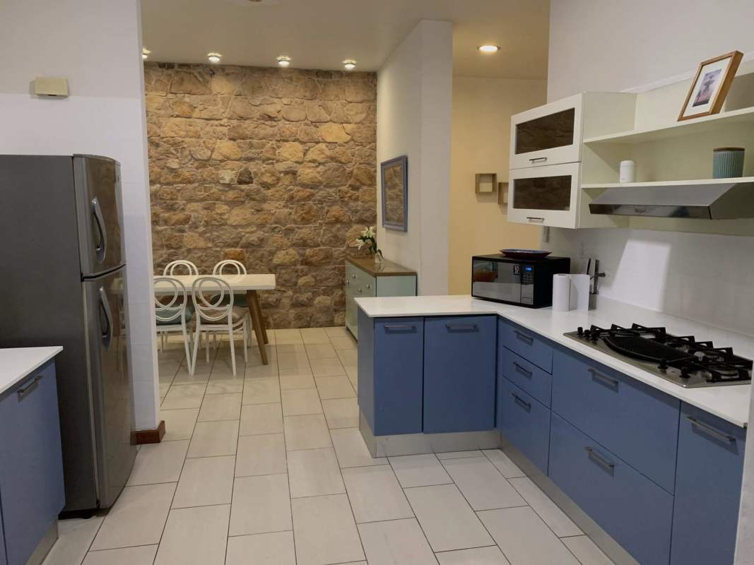 Contemporary kitchen with stone accent wall, granite countertops in Casco Viejo apartment Panama