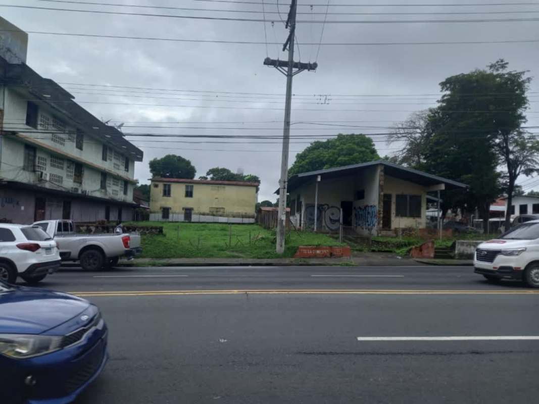 Vacant corner lot surrounded by mixed-use buildings and streets in Panama City El Ingenio sector.