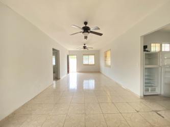 Covered porch with balustrade railing overlooking countryside in gated Sajalices residence Panama