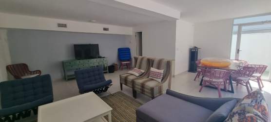 Open-concept living and dining space with natural light, coastal design, surfboard art in luxury villa Playa Blanca Panama