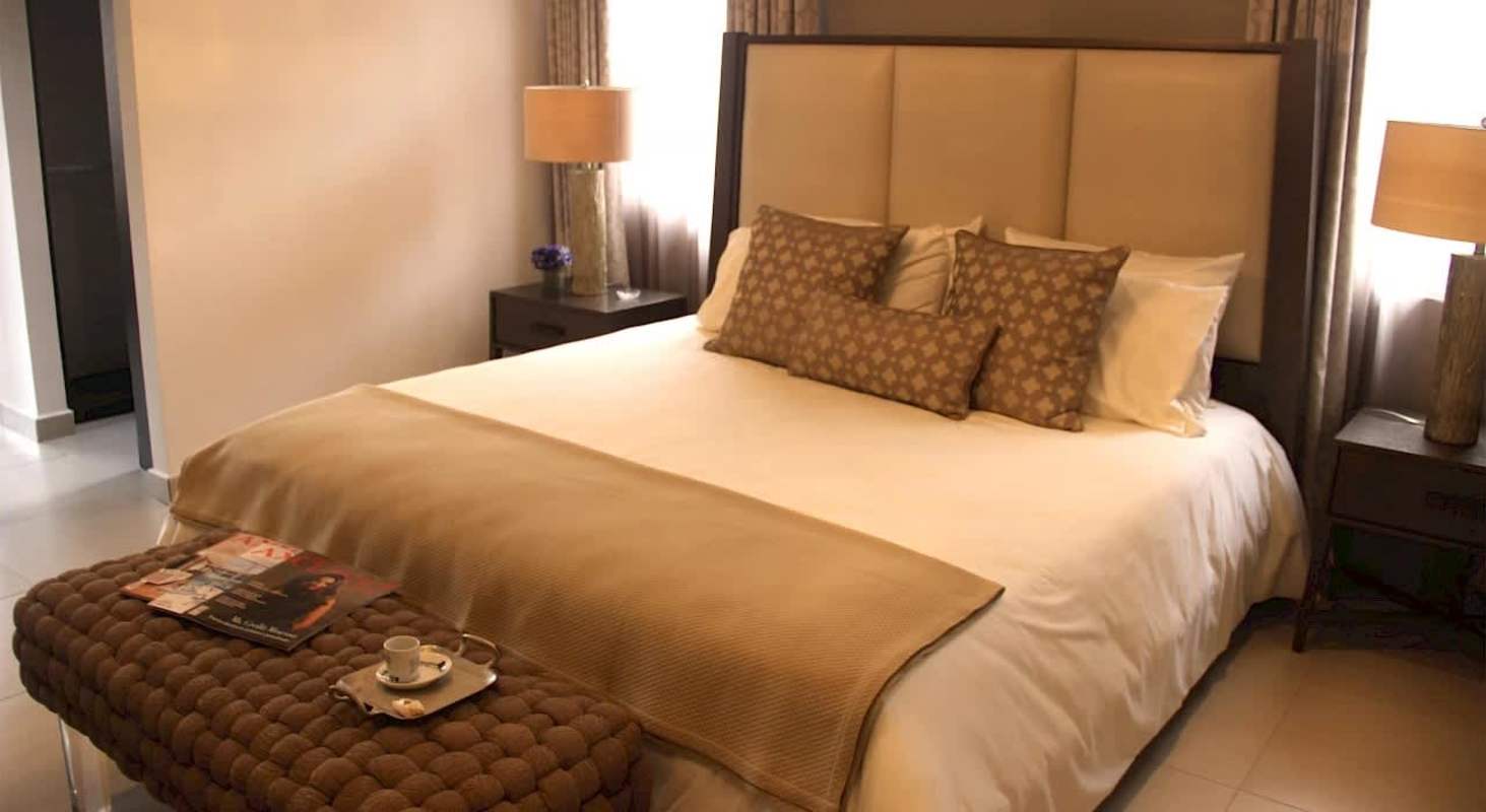 Master bedroom with upholstered bed, side tables and stylish decor in luxury home Costa Sur Panama