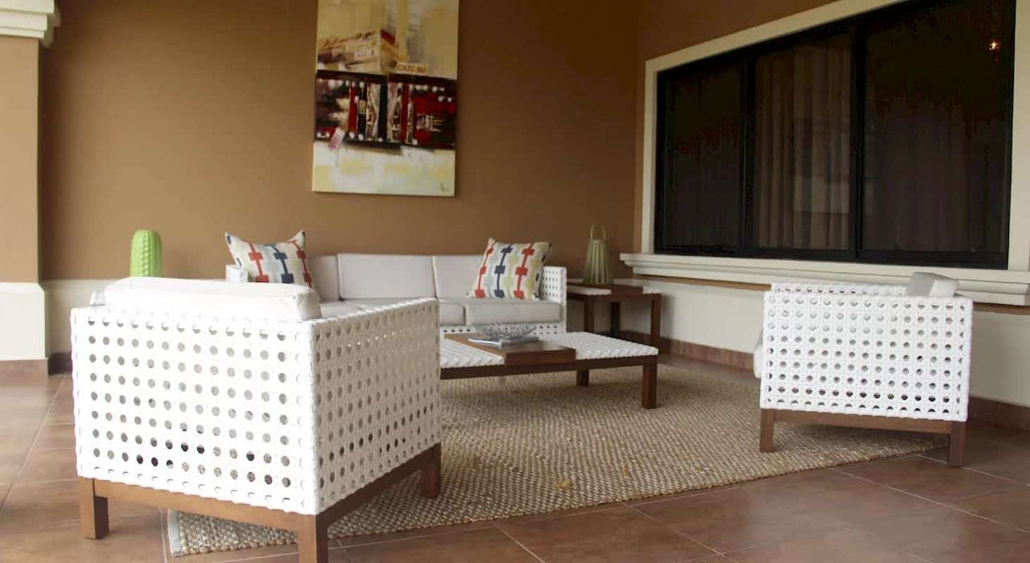Covered veranda patio with modern white furniture and art in Costa Sur Panama