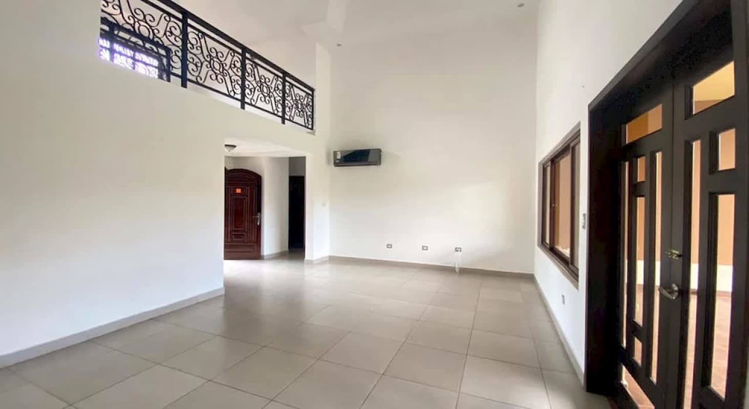 Spacious living area with tile floors, ironwork balcony railing and large windows at Sunset Coast Costa Sur