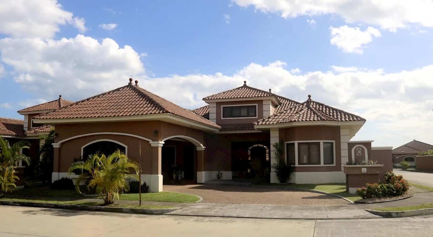 Beautiful Mediterranean-style house exterior with terracotta roof and landscaped yard in Sunset Coast Costa Sur Panama