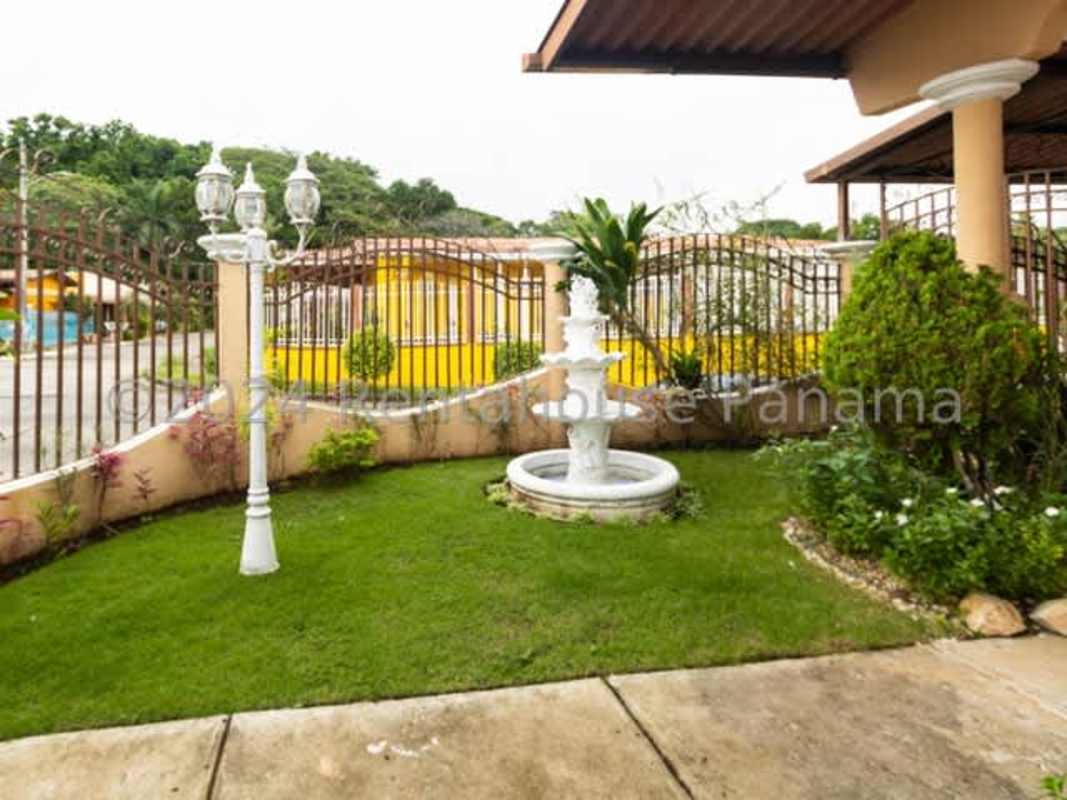 Landscaped front garden with fountain and iron fence house in Brisas del Golf Panama City
