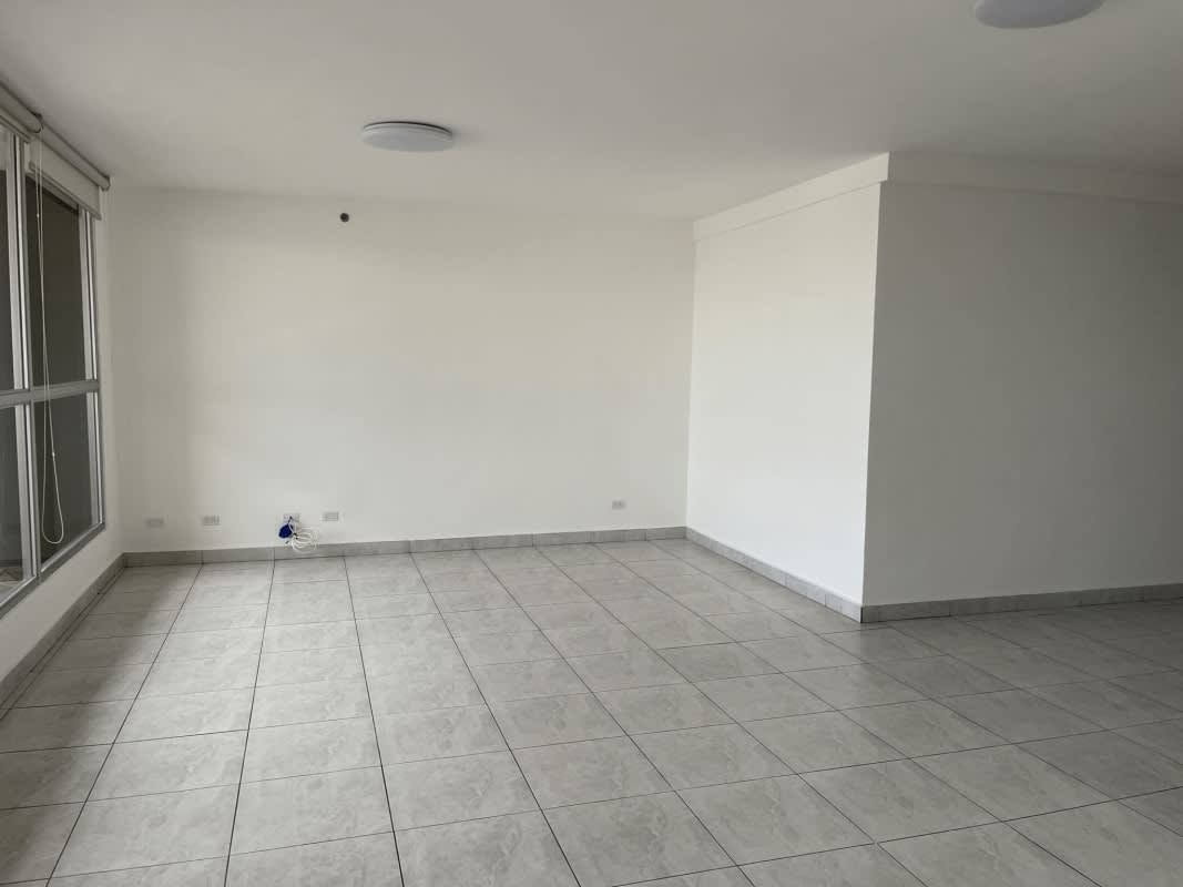 Open living room with large window, tiled floor, white walls in PH El Cangrejo Tower Panama City