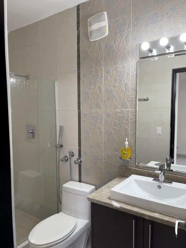 Kitchen with granite countertops, pendant lighting, stainless fridge in PH El Cangrejo Tower apartment Panama