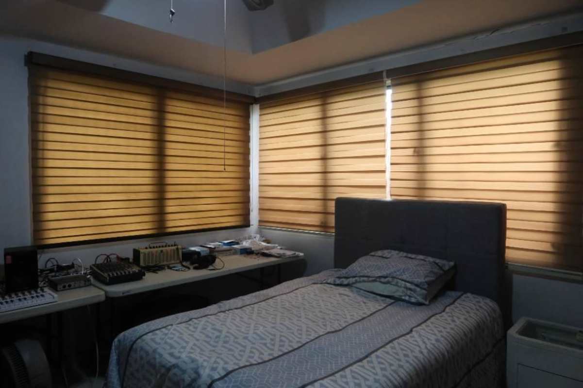 Bedroom with desk, large windows, AC unit, and contemporary decor in Panama home for sale
