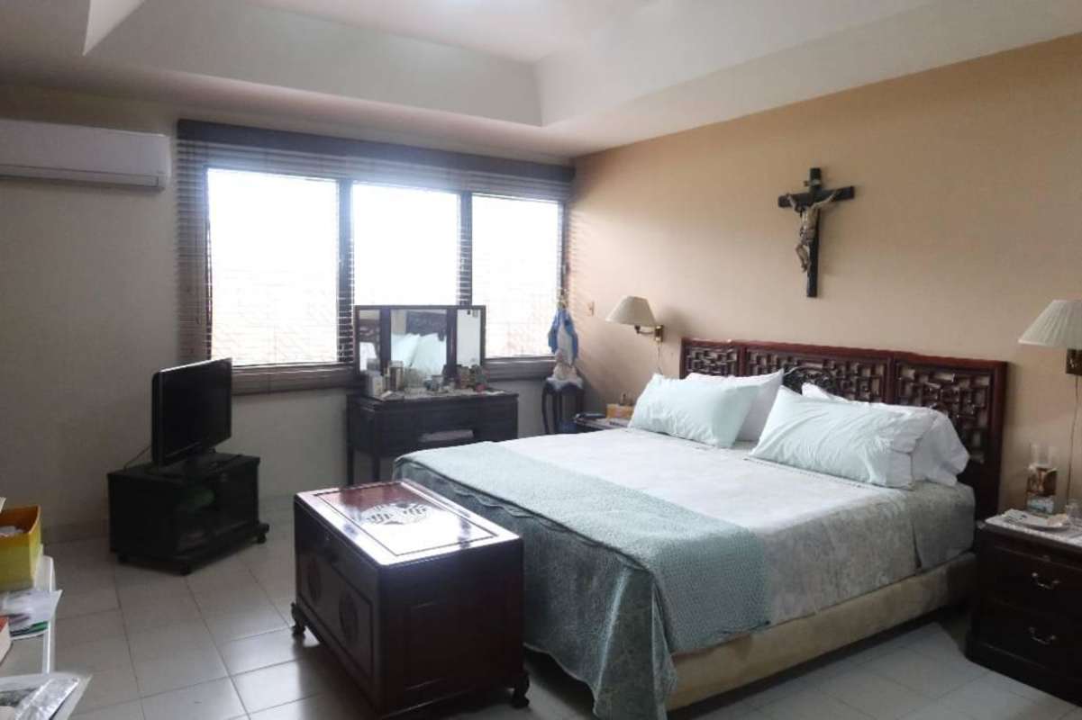 Spacious master bedroom with large window, AC, king bed, and vanity table in Panama City