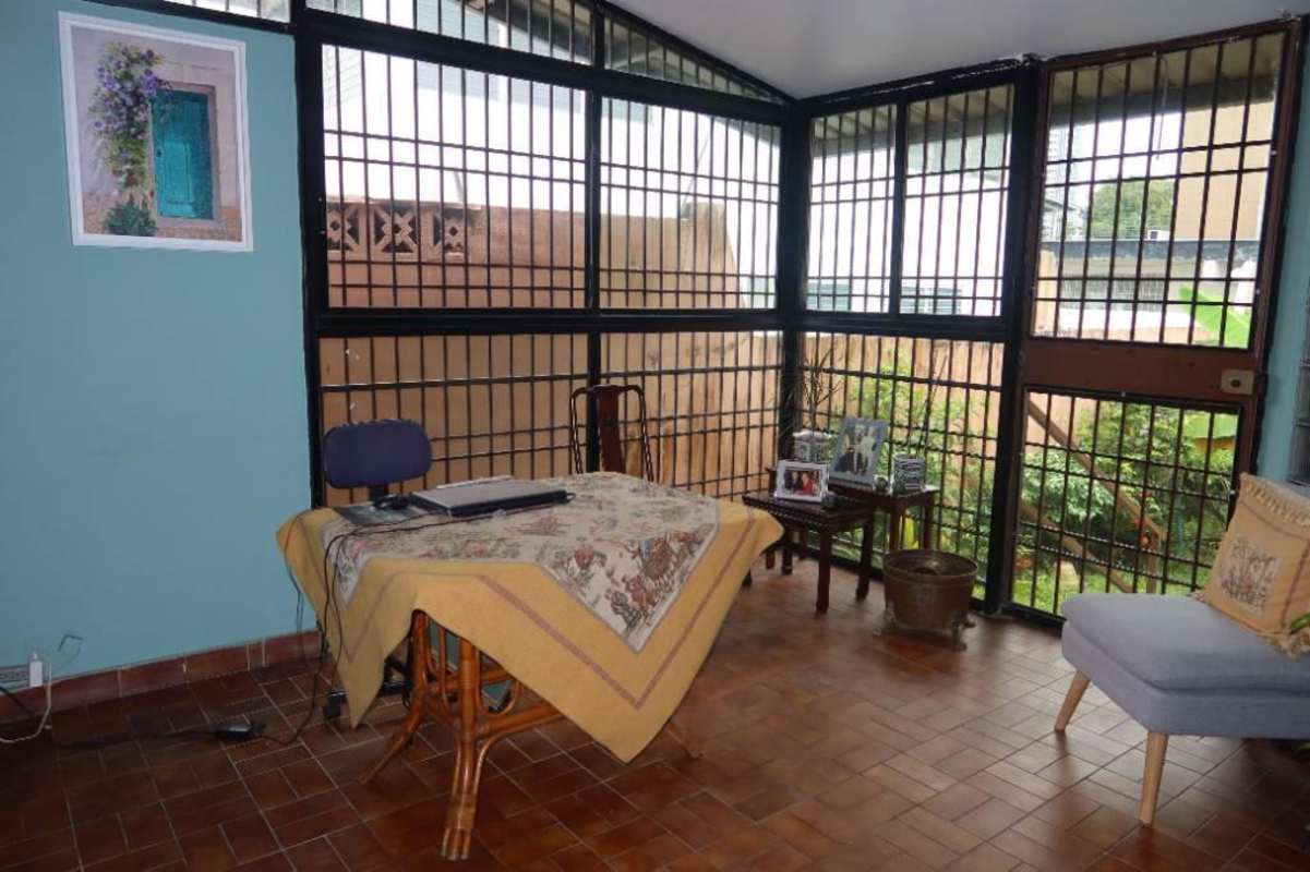 Enclosed sunroom with tiled floors and floor-to-ceiling security bars in spacious Panama house