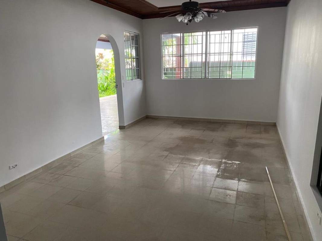 Spacious living room with arched doorway, ceramic tile floor, garden view in San Francisco Panama