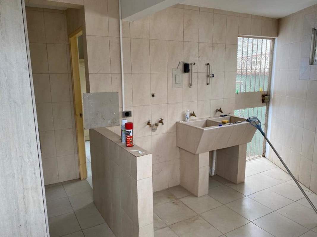 Covered outdoor patio with red tiles, metal security doors, garden view in San Francisco Panama