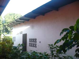 Basic exterior of one-story house with garden in Chiriqui province Panama