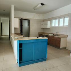 Fully equipped kitchen with blue island, beige countertops, tile backsplash Punta Barco house Panama