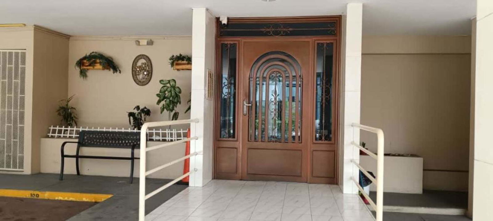 Ornate building entrance with accessibility ramp and plants PH Villa de las Fuentes Panama