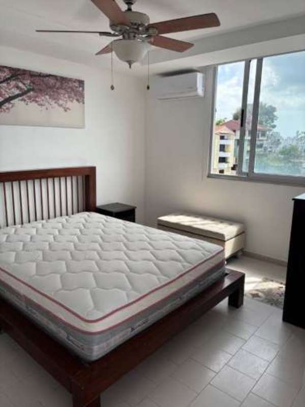 Bright bedroom with large window, laminate flooring, and AC in PH Villa de las Fuentes
