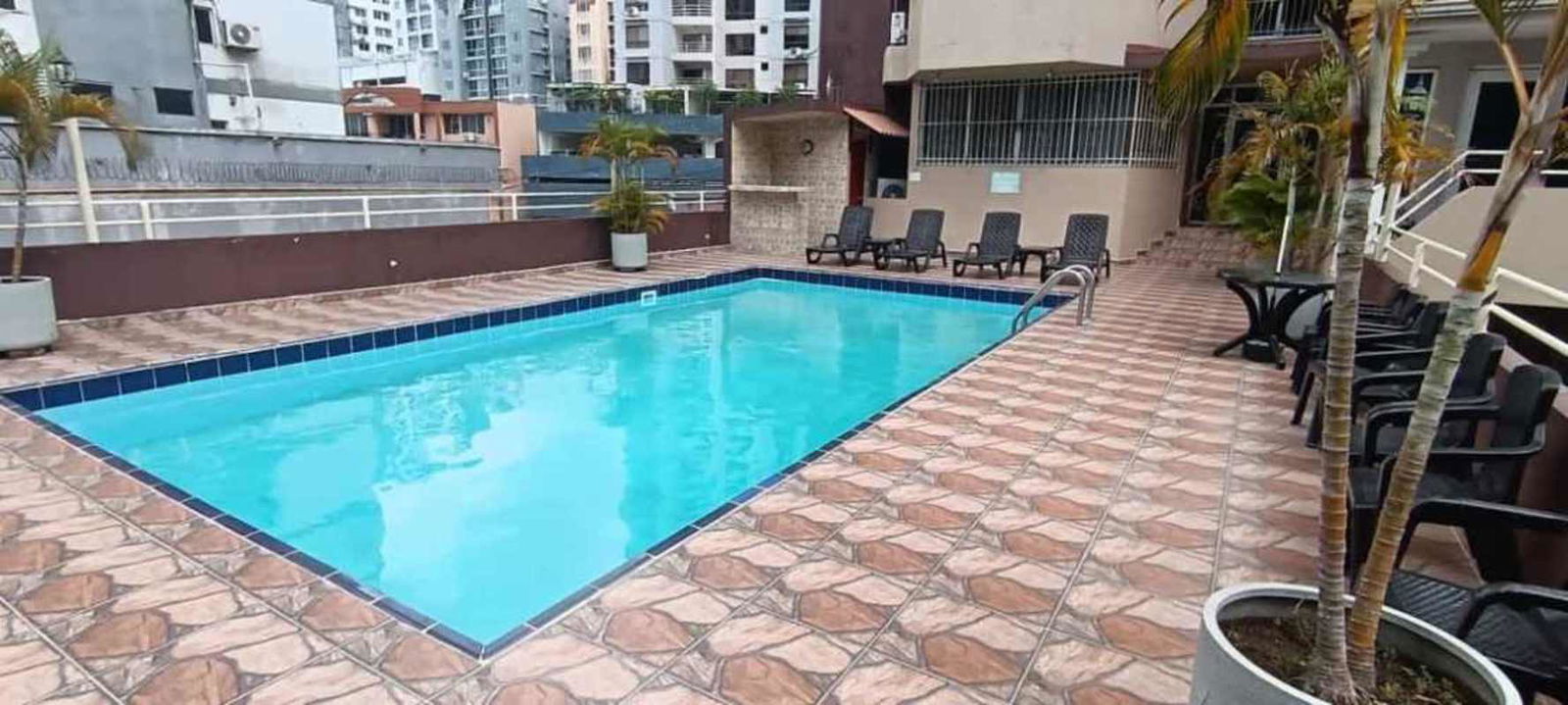 Outdoor pool area with palm trees and seating PH Villa de las Fuentes Panama