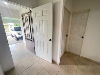 Exterior of white corner lot house with tiled roof and yard for rent Chiriquí Panama