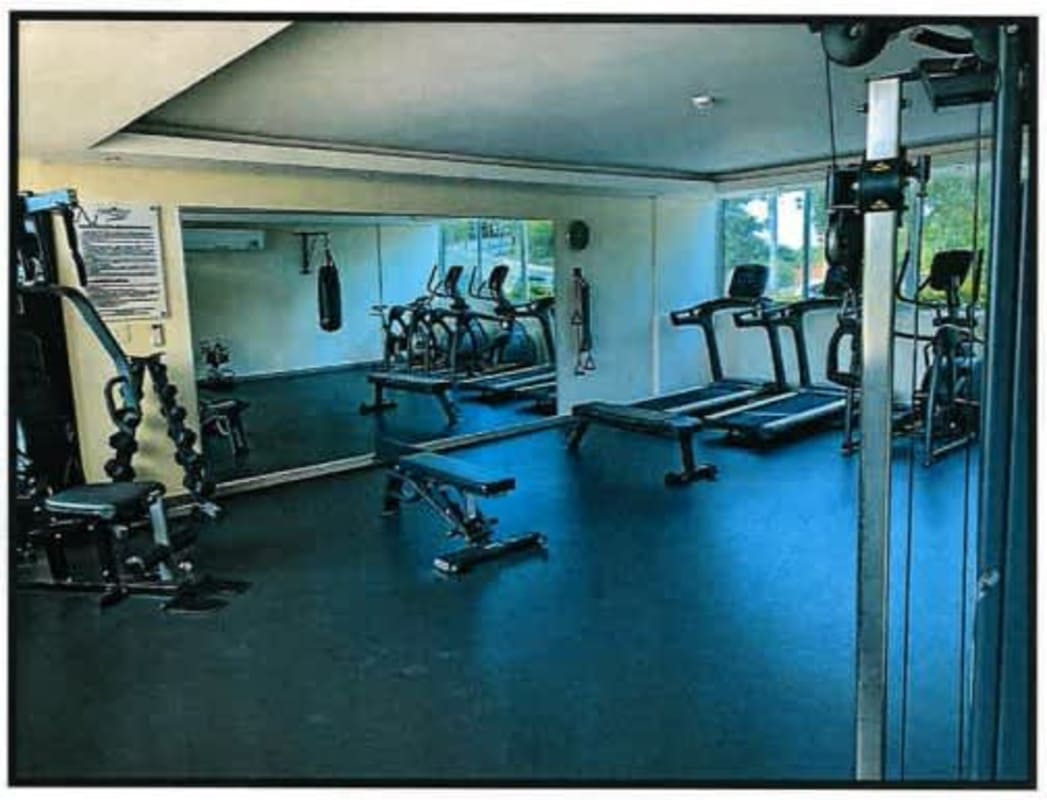Modern gym with exercise equipment, mirrors, natural light at PH Pine Hills Albrook Clayton Panama