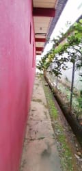 Narrow exterior walkway with fencing and garden at Villa Salvador Chitré home