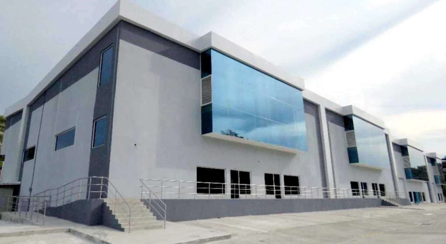Industrial warehouse exterior with elevated concrete dock and large roll-up doors Parque Centenario Panama